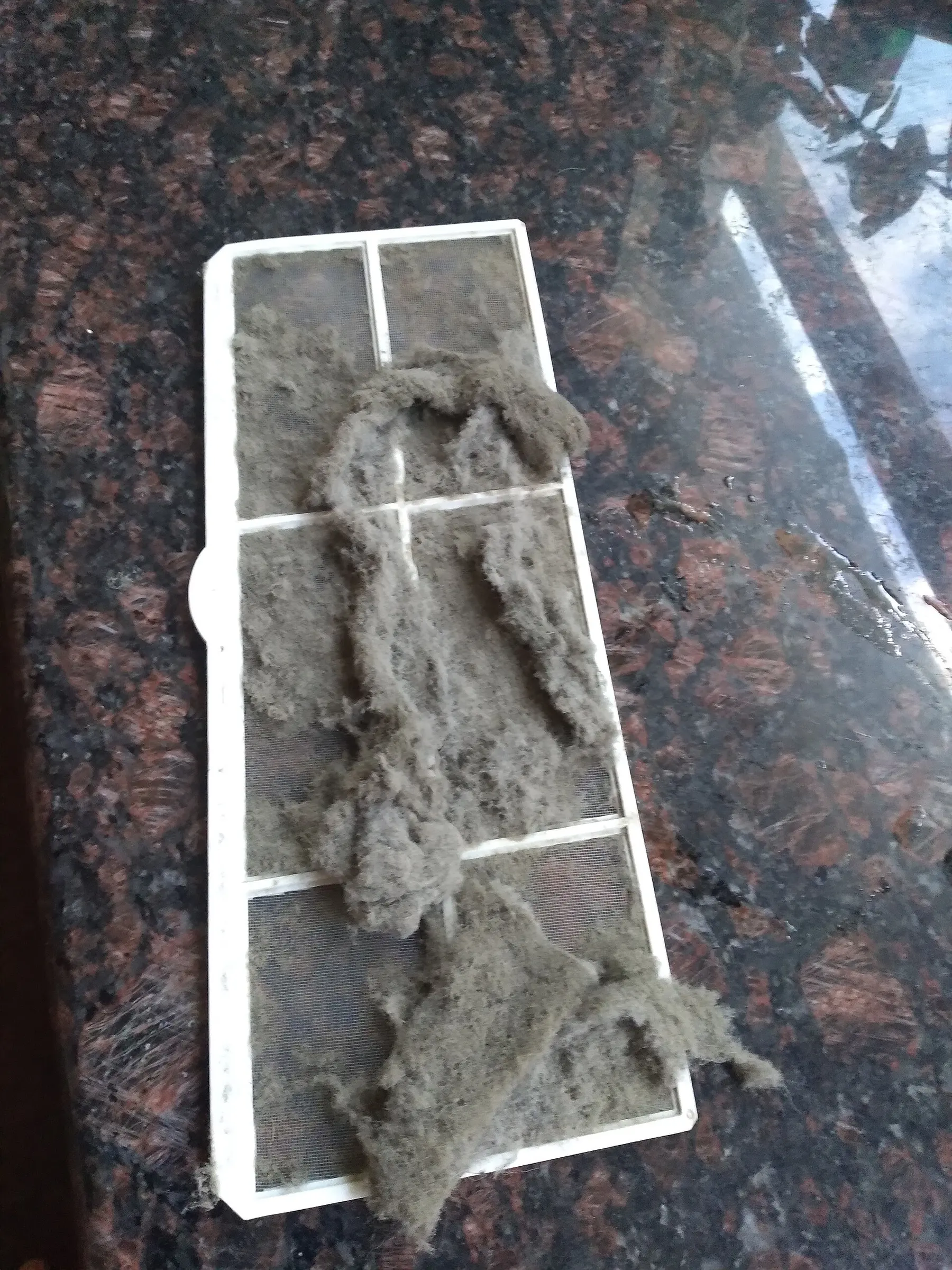 Bingkai penapis udara diliputi lapisan tebal habuk kelabu
