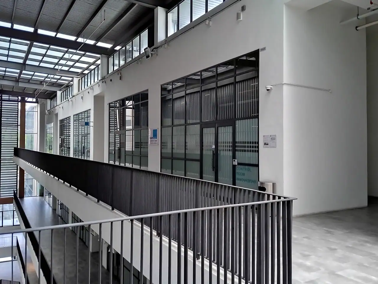 Open corridor on level 5 of the Emporis podium with a green wall and empty shop units
