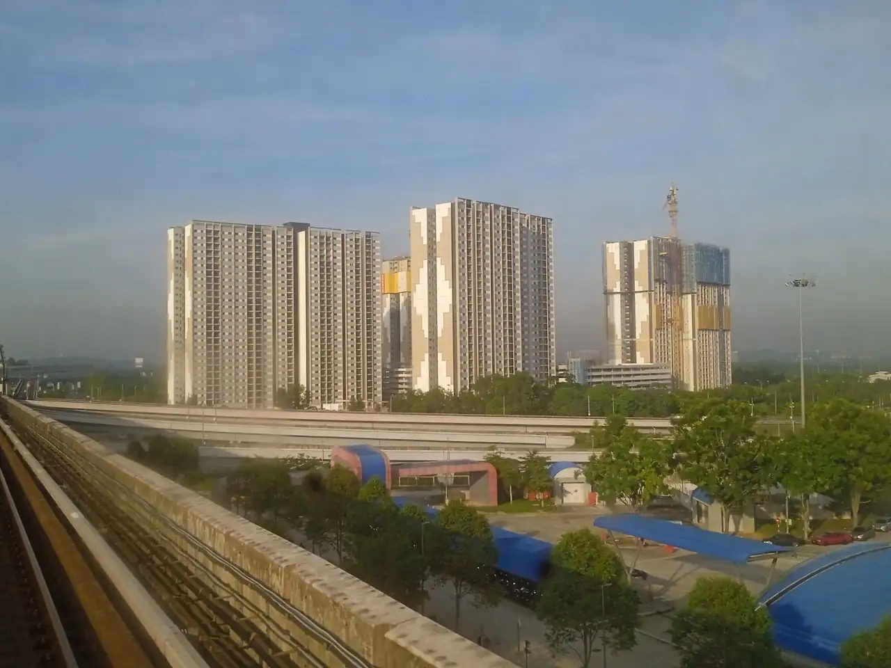The Idaman blocks in morning light beside the MRT viaduct
