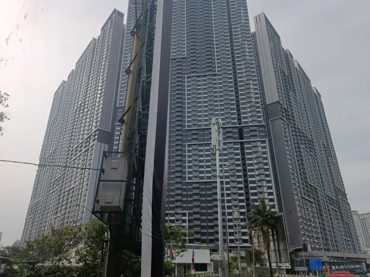 M Vertica tower facade with stepped balconies beside the road