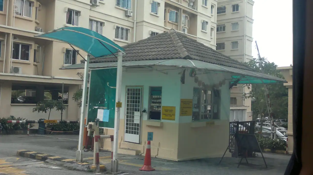 Guardhouse with a teal canopy at the foot of an Oakleaf Park block