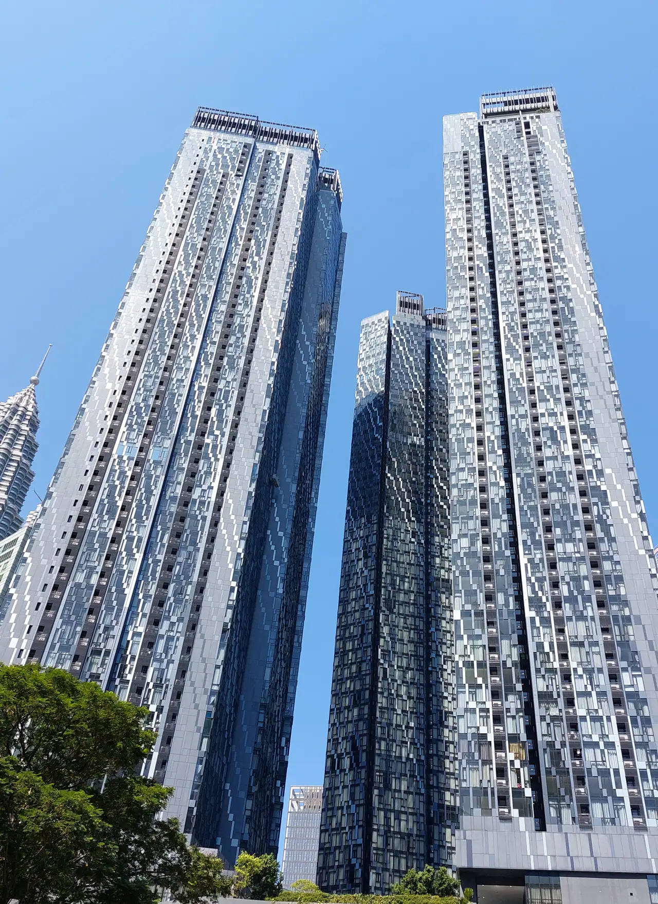 The three towers of Star Residences seen from the east, looking up at the facades against a blue sky