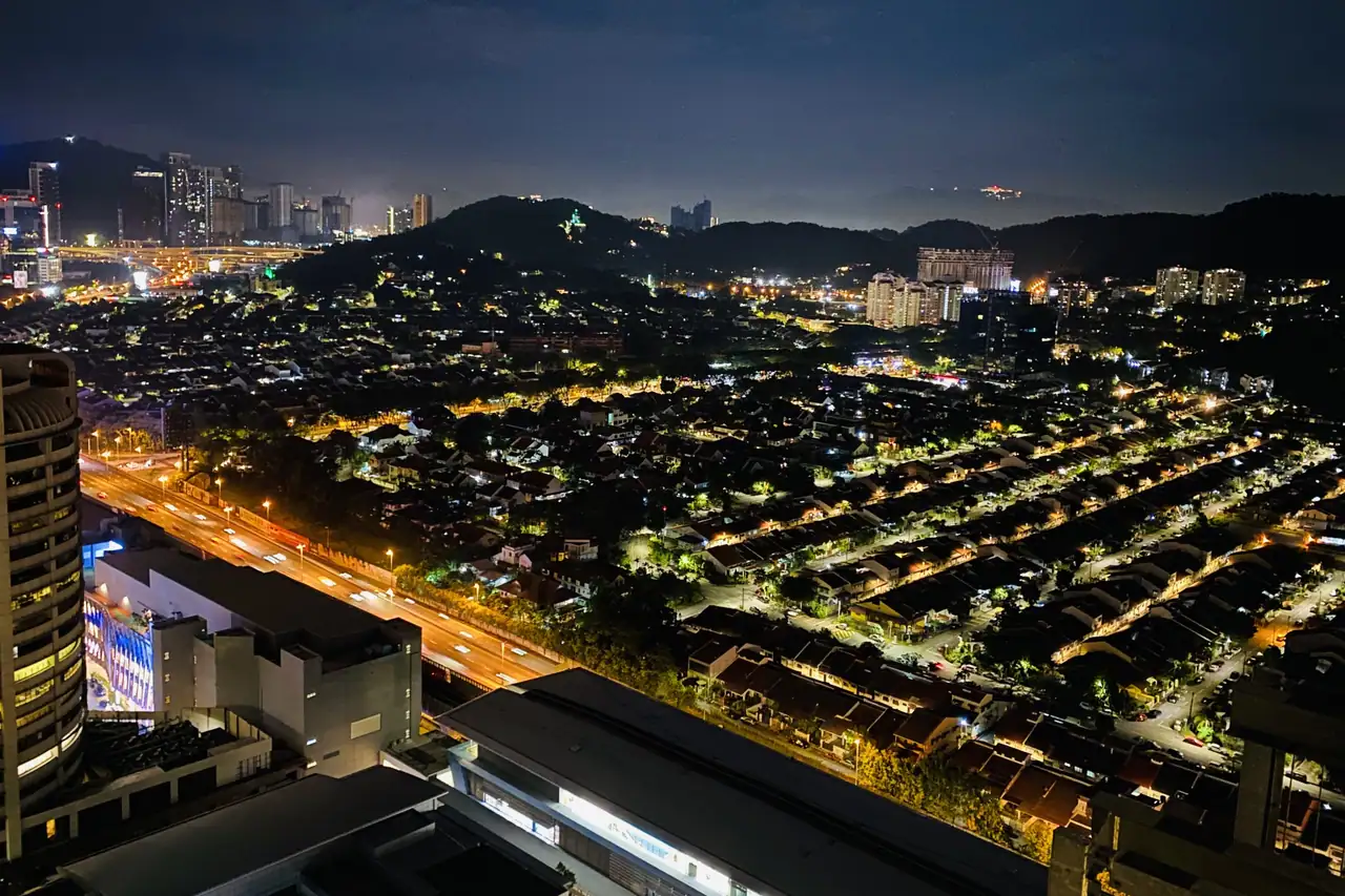 Taman Tun Dr Ismail at night, looking north-east, with the terrace rows lit and traffic on the expressway